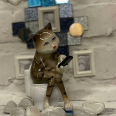 Tabby Cat sitting on the Toilet